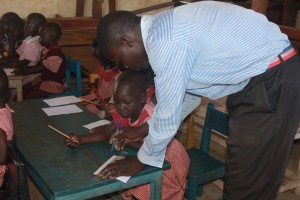St Kizito Denis helping a pupil