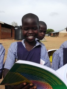 Betty Alum 12 years old in Primary 3 is very excited to see a pupil's text book for the first time in their school.