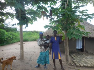 Sarah with the Mum at their home under the papaya fruit trees