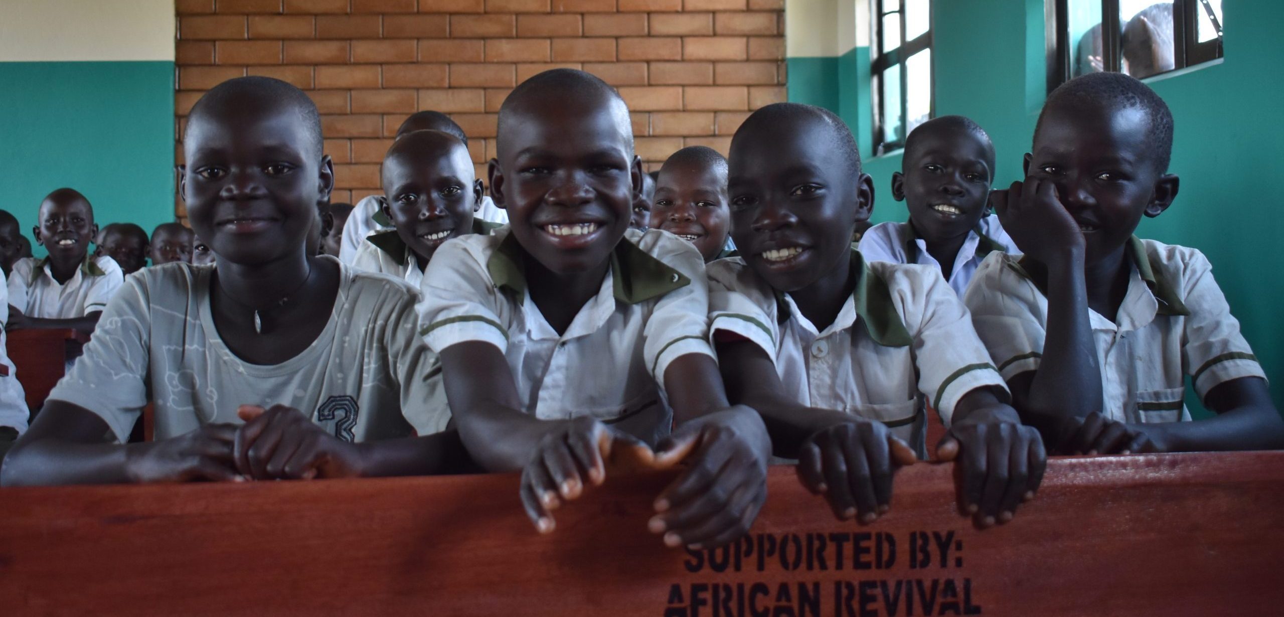 African Revival group of students smiling in a classroom